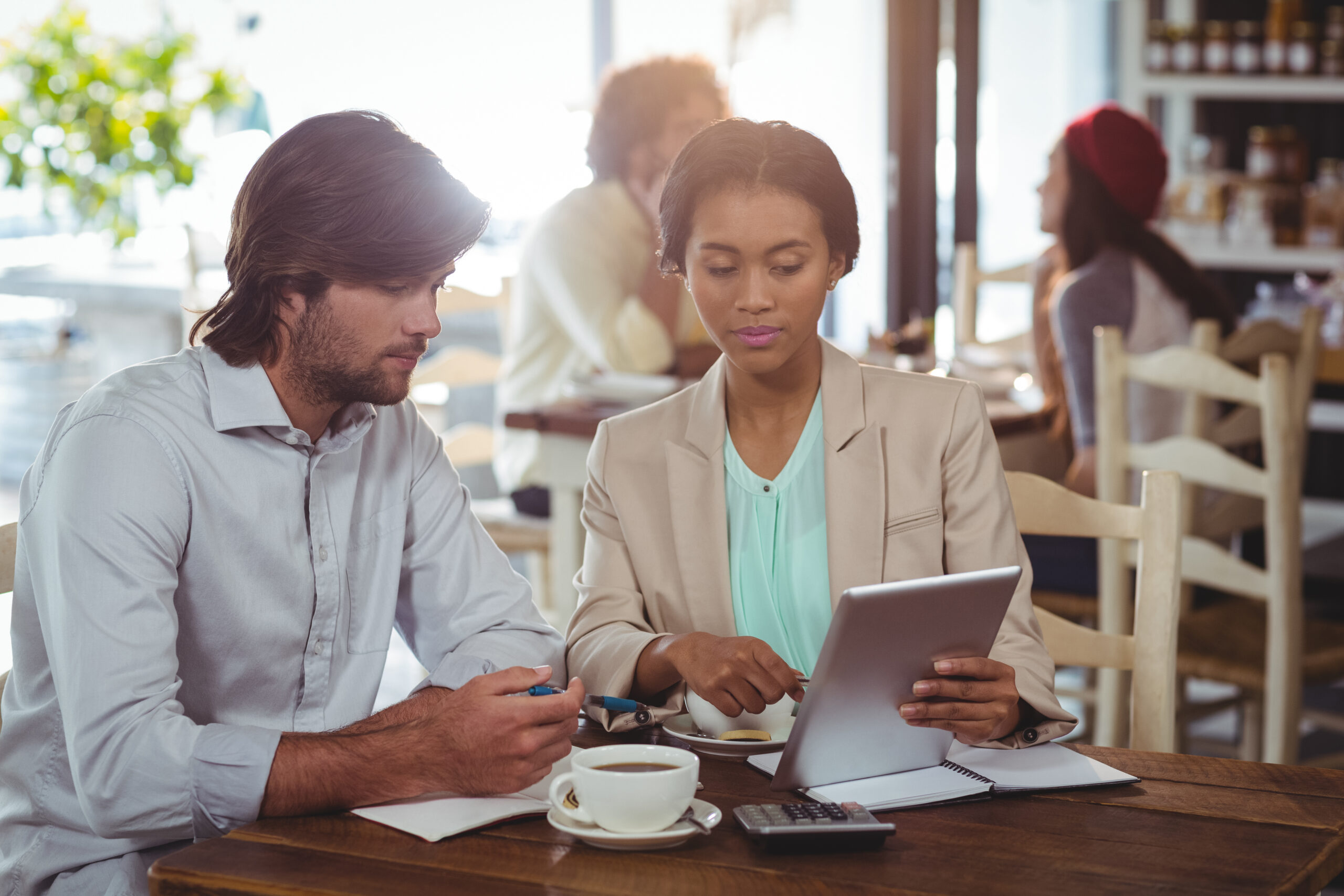 Man and woman using a digital tablet during meeting